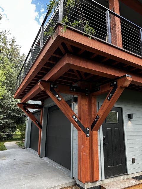 Stained timber deck supports with black steel plates