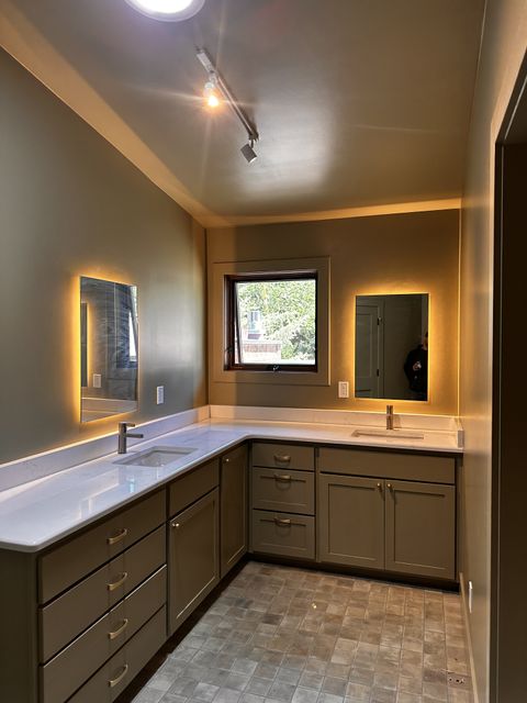 L-shaped double vanity with backlit mirrors